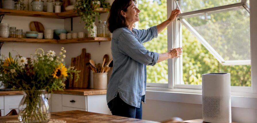 Woman adjusting curtains to improve home air quality