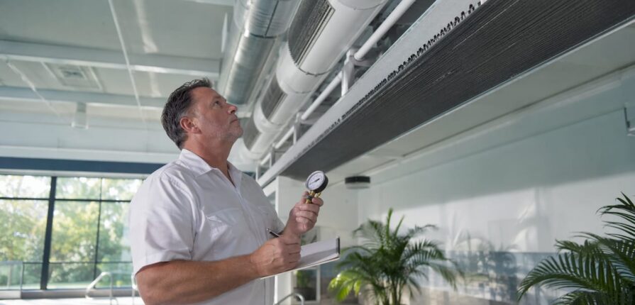 Technician inspecting indoor pool HVAC system