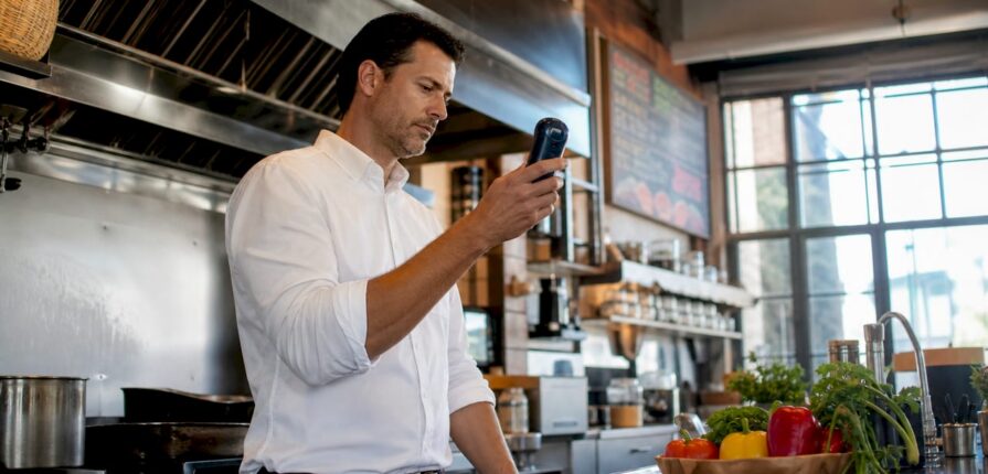 Restaurant manager checking air quality monitor indoors