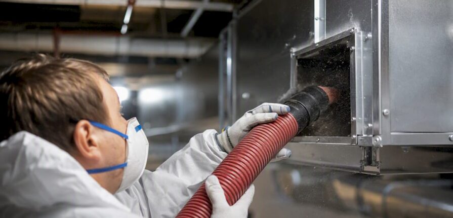 Technician cleaning commercial HVAC duct