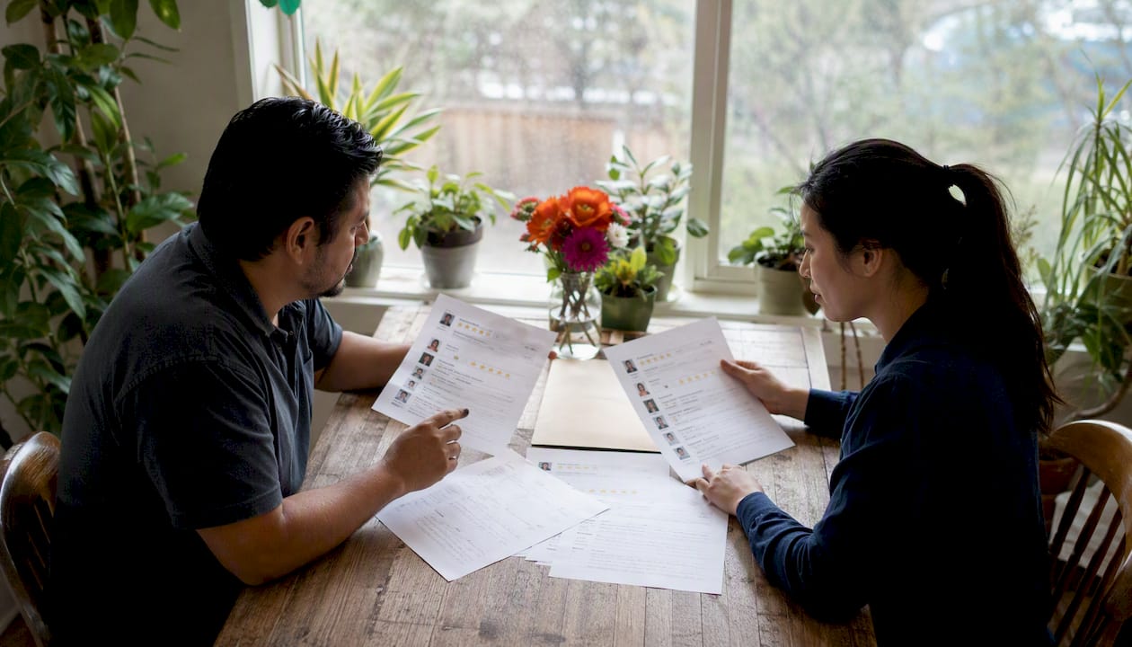 Hands holding HVAC customer reviews on table